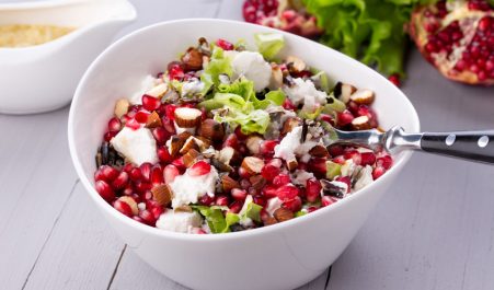 36633156 - healthy salad with pomegranate seeds, almond, feta cheese and black rice in white bowl.